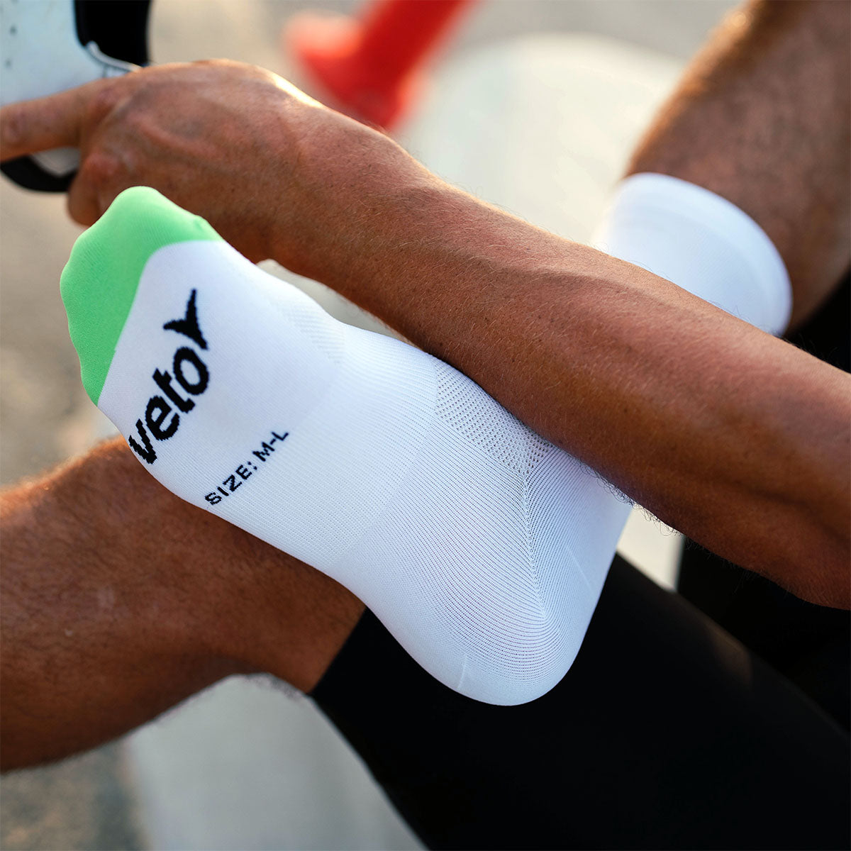 Rider inspecting features of Veto Cycling 1.0 sock